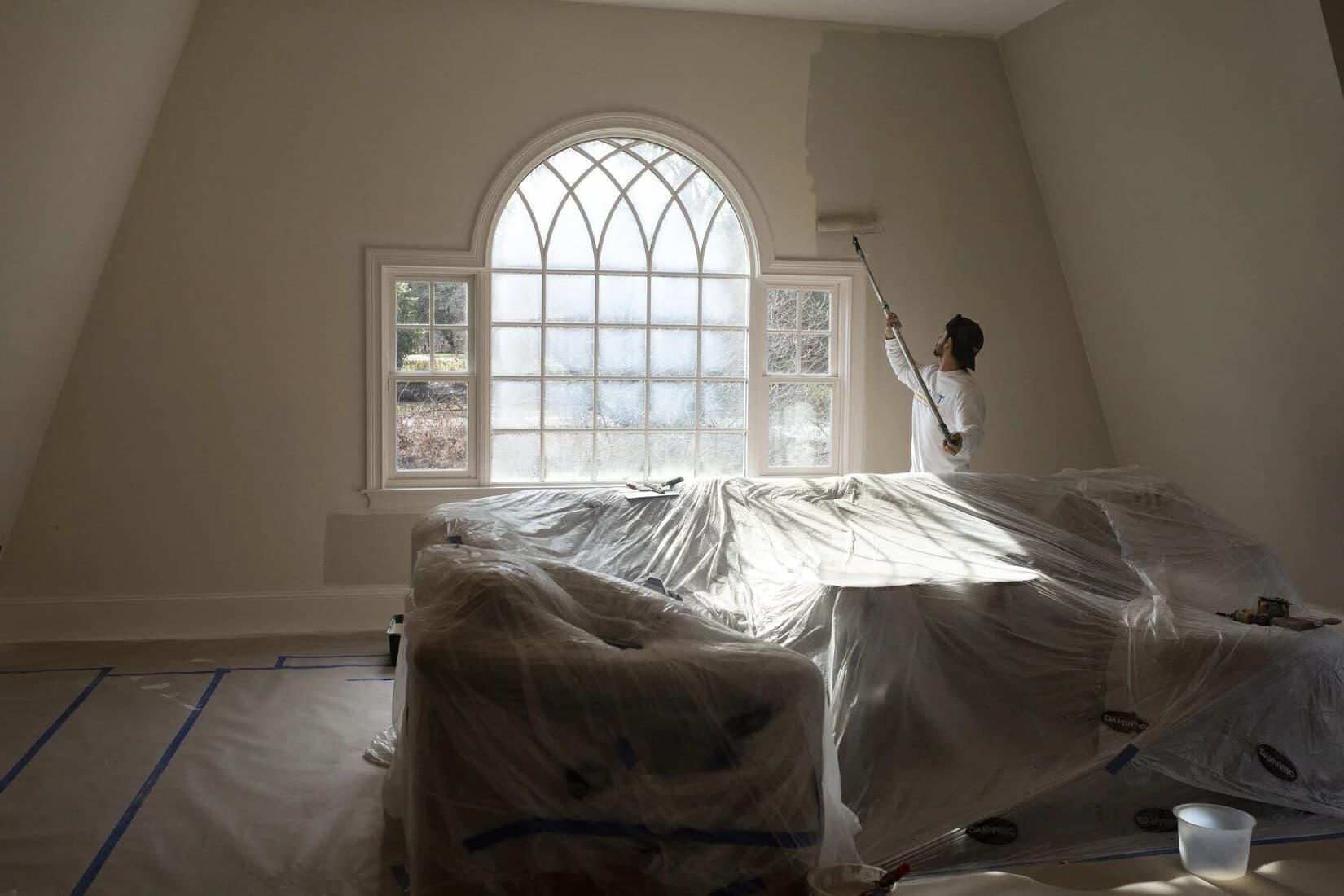 Interior bedroom wall being freshly rolled by a Bay City Painters crew member in Hamilton, Ontario